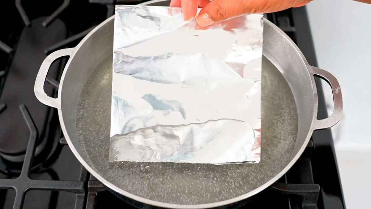 Mettre une feuille de papier d'aluminium dans de l'eau bouillante
